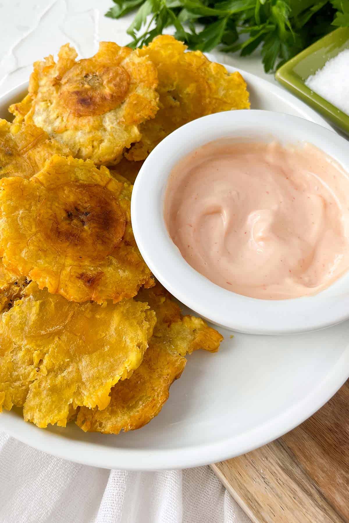 fried green plantains with a side of mayoketchup sauce on the side.