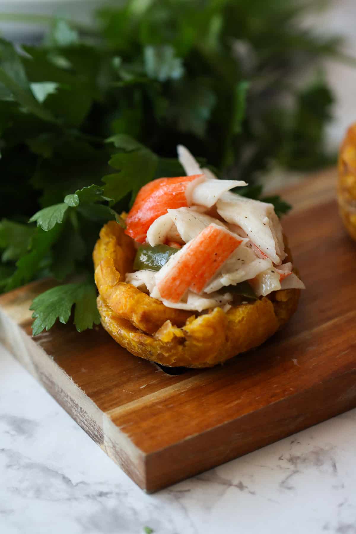close up of a stuffed plantain cup with king crab salad- toston relleno de king crab.