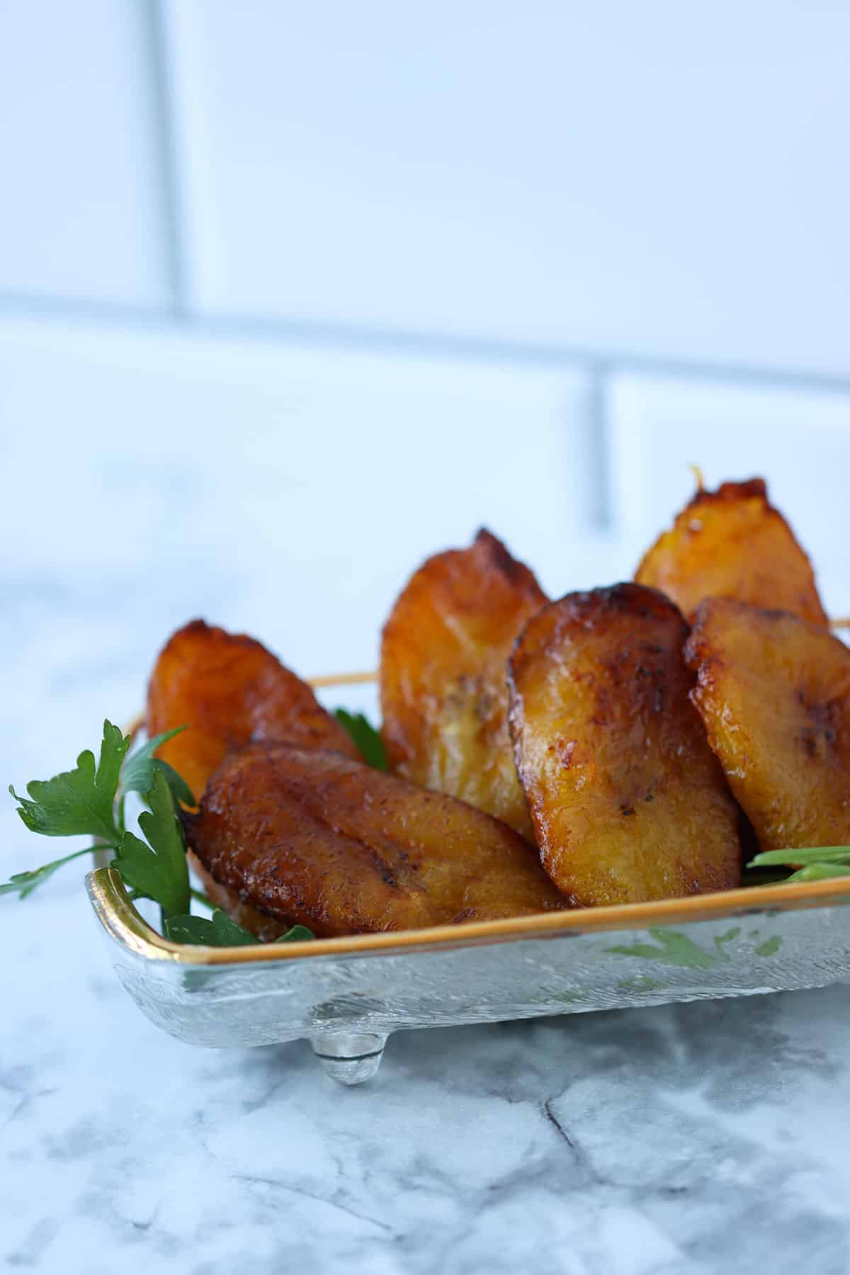 close up of amarillos or sweet fried plantains in a glass dish.
