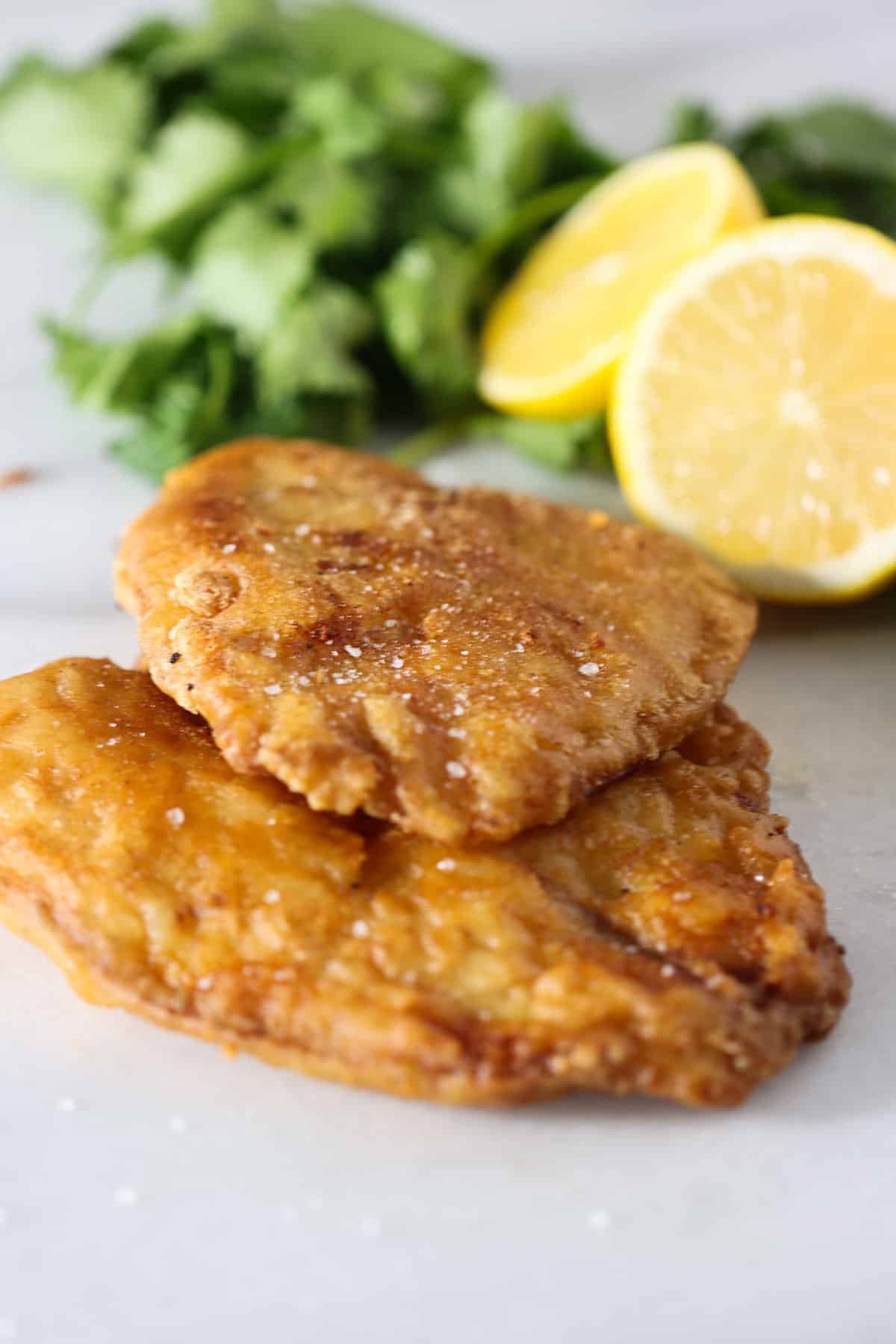 fried tilapia with a couple of lemon wedges.