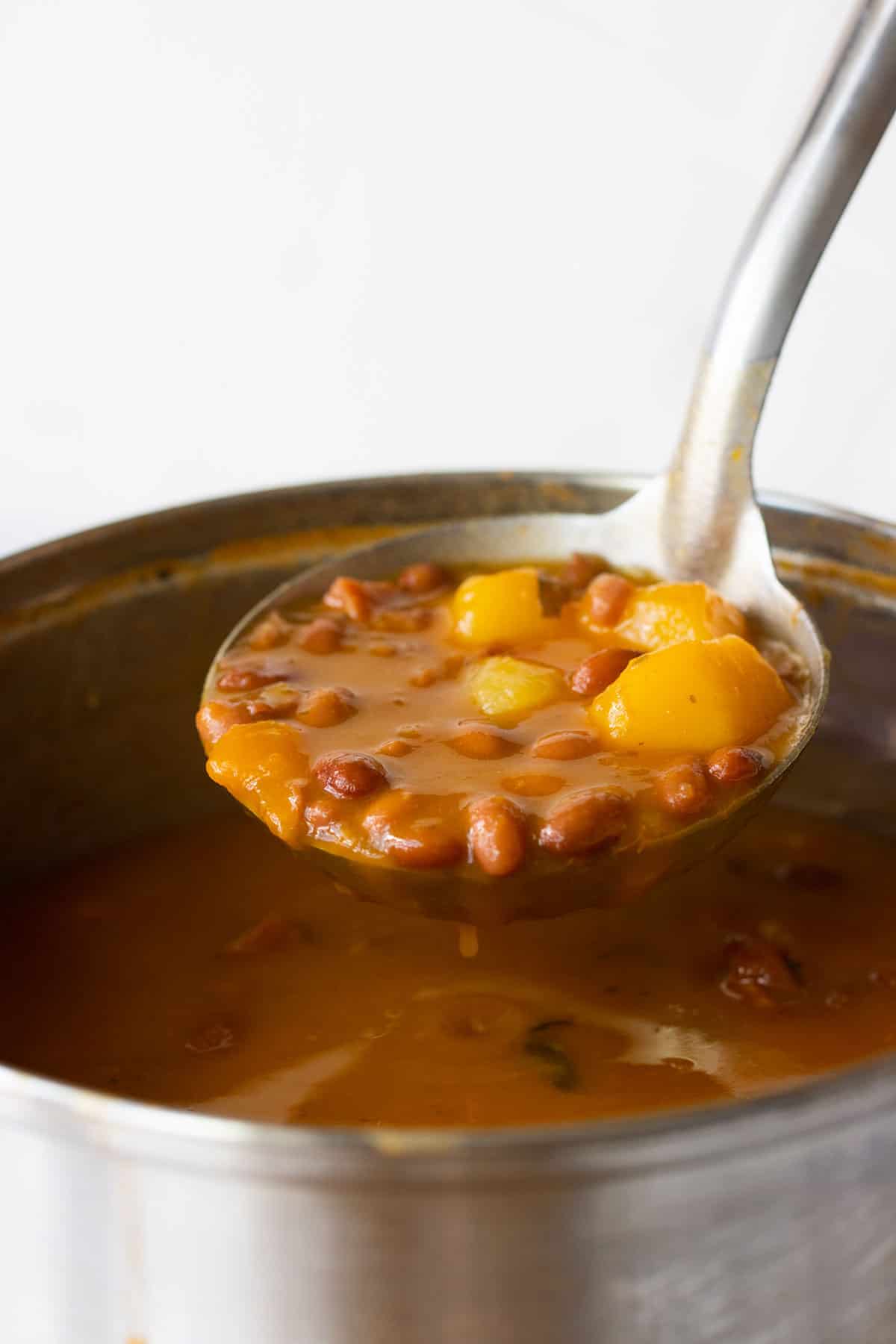 a ladle full of stewed beans.