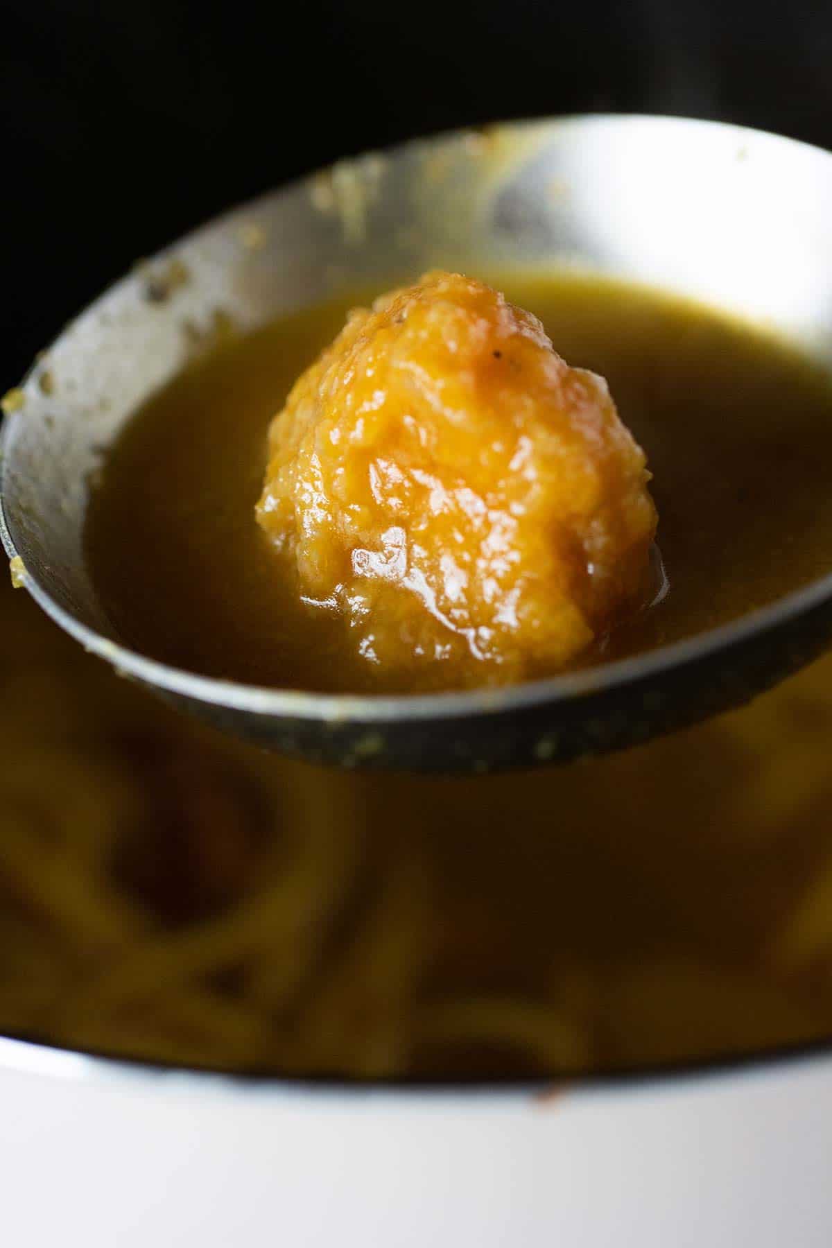 plantain ball close up on a laddle with soup.