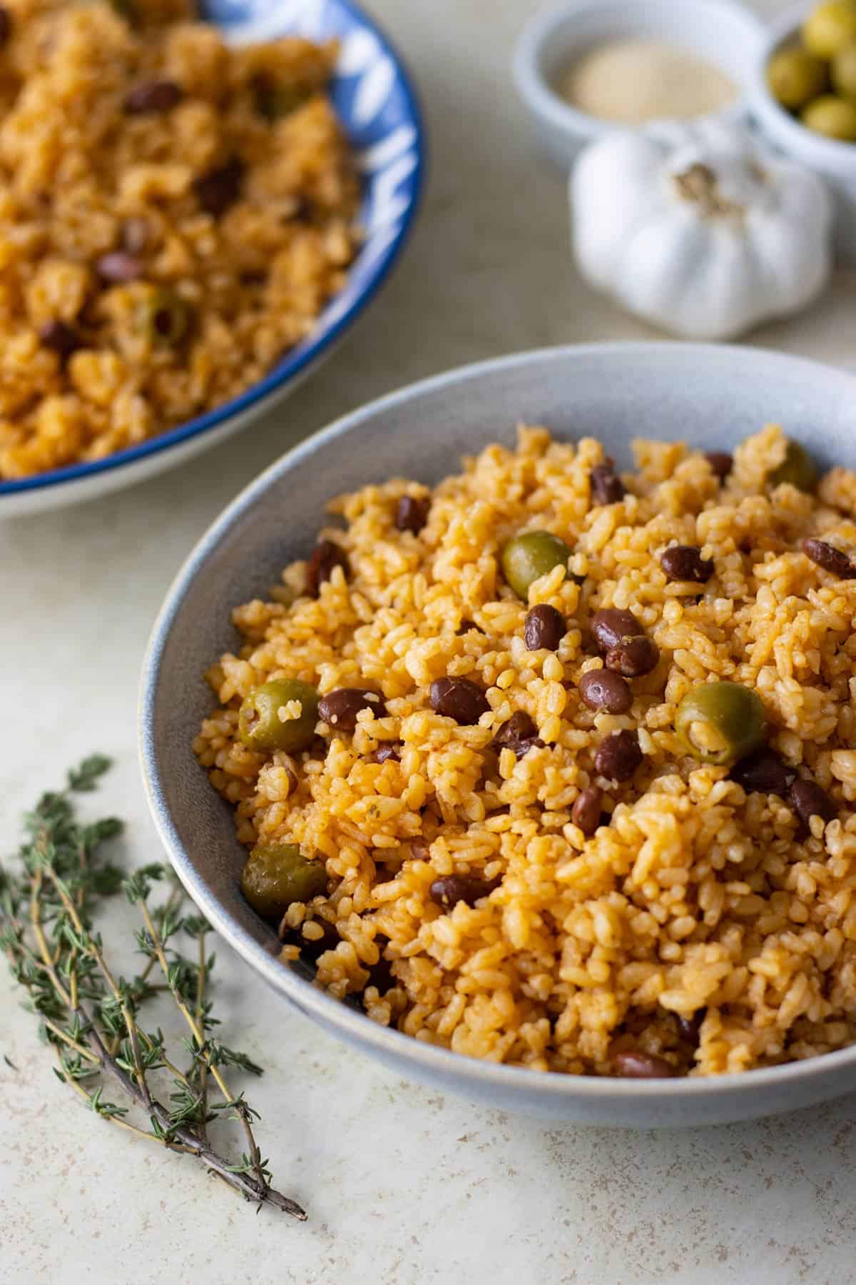 2 bowls of puerto rican rice and beans or arroz guisado with a piece of thyme on the side.