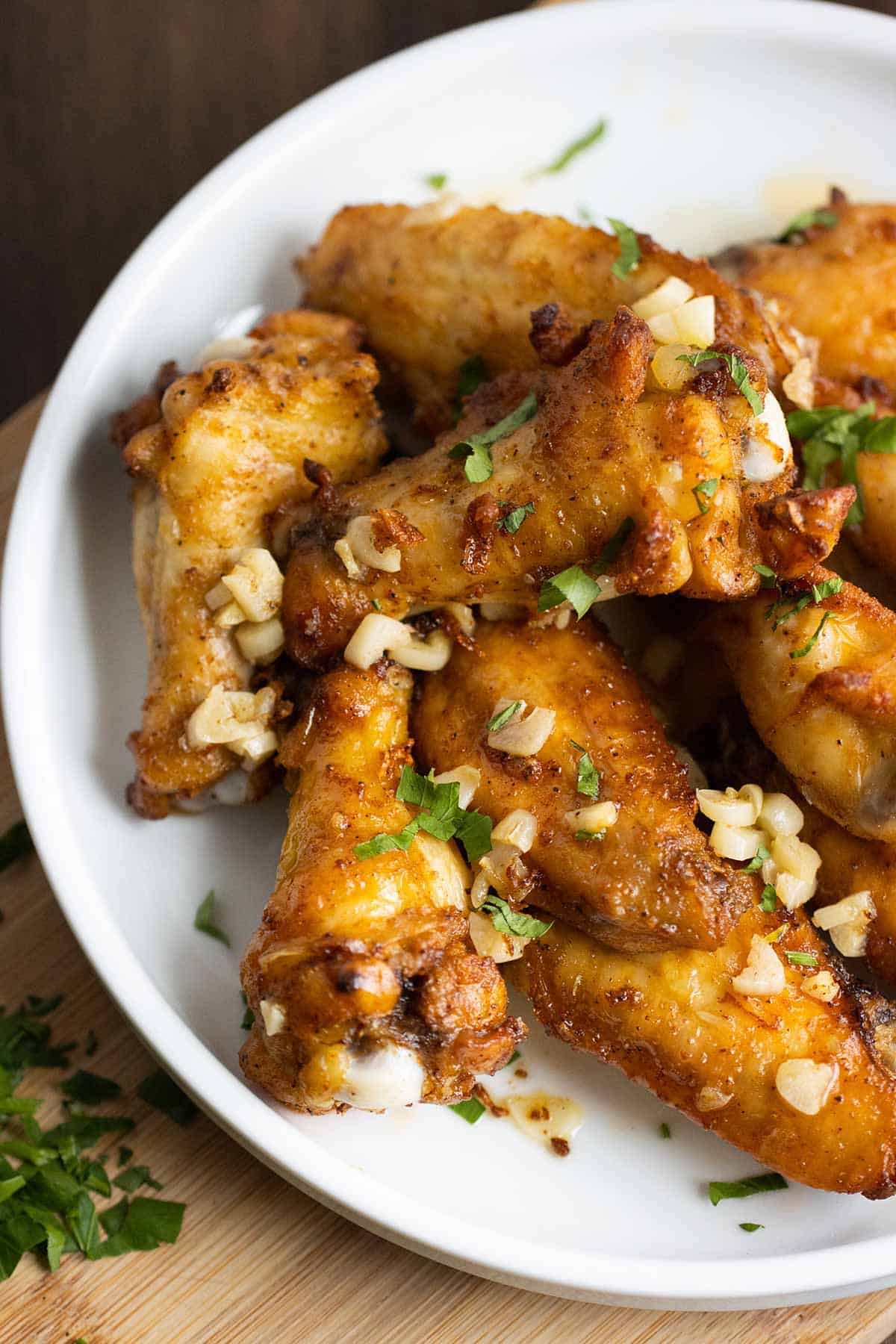 white plate full of garlic butter chicken wings.