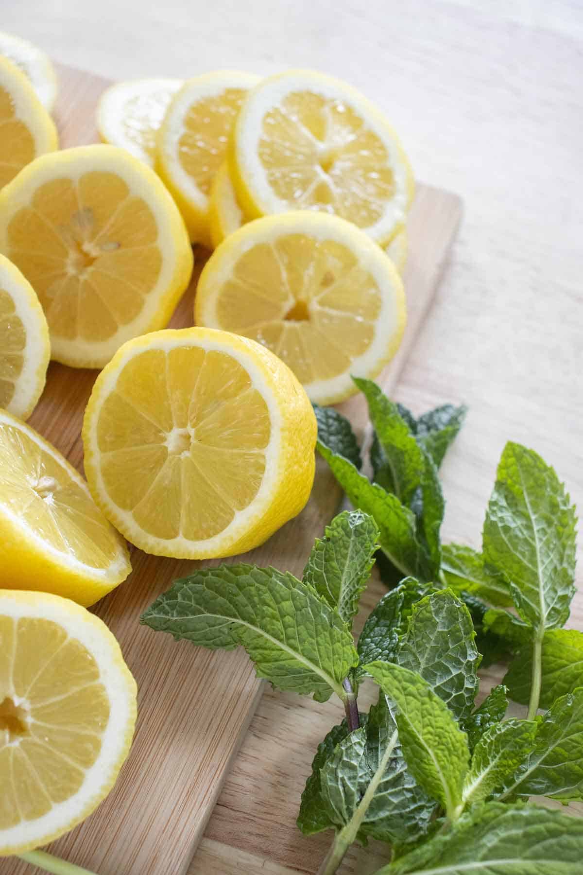 alot of lemons cut in half and into wheel and alot of mint on the side.