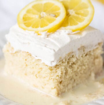 plate with a big piece of a lemon tres leches decorated with lemons on top.