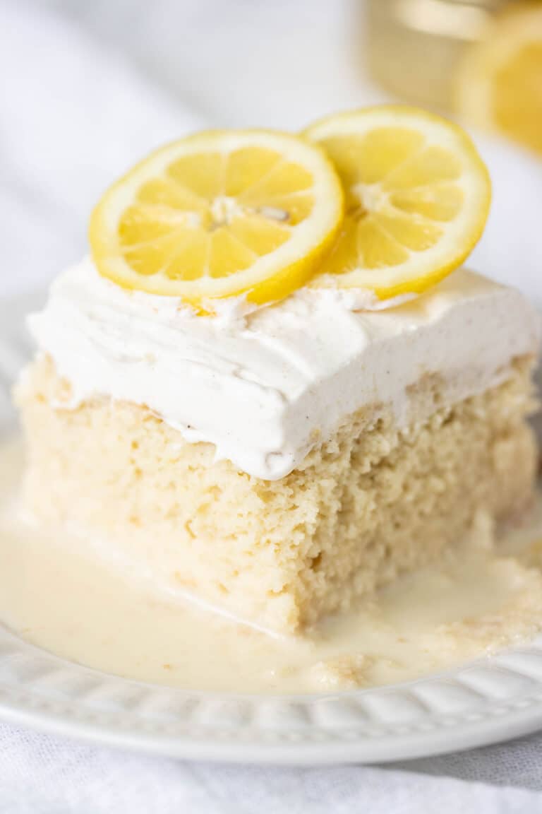 plate with a big piece of a lemon tres leches decorated with lemons on top.