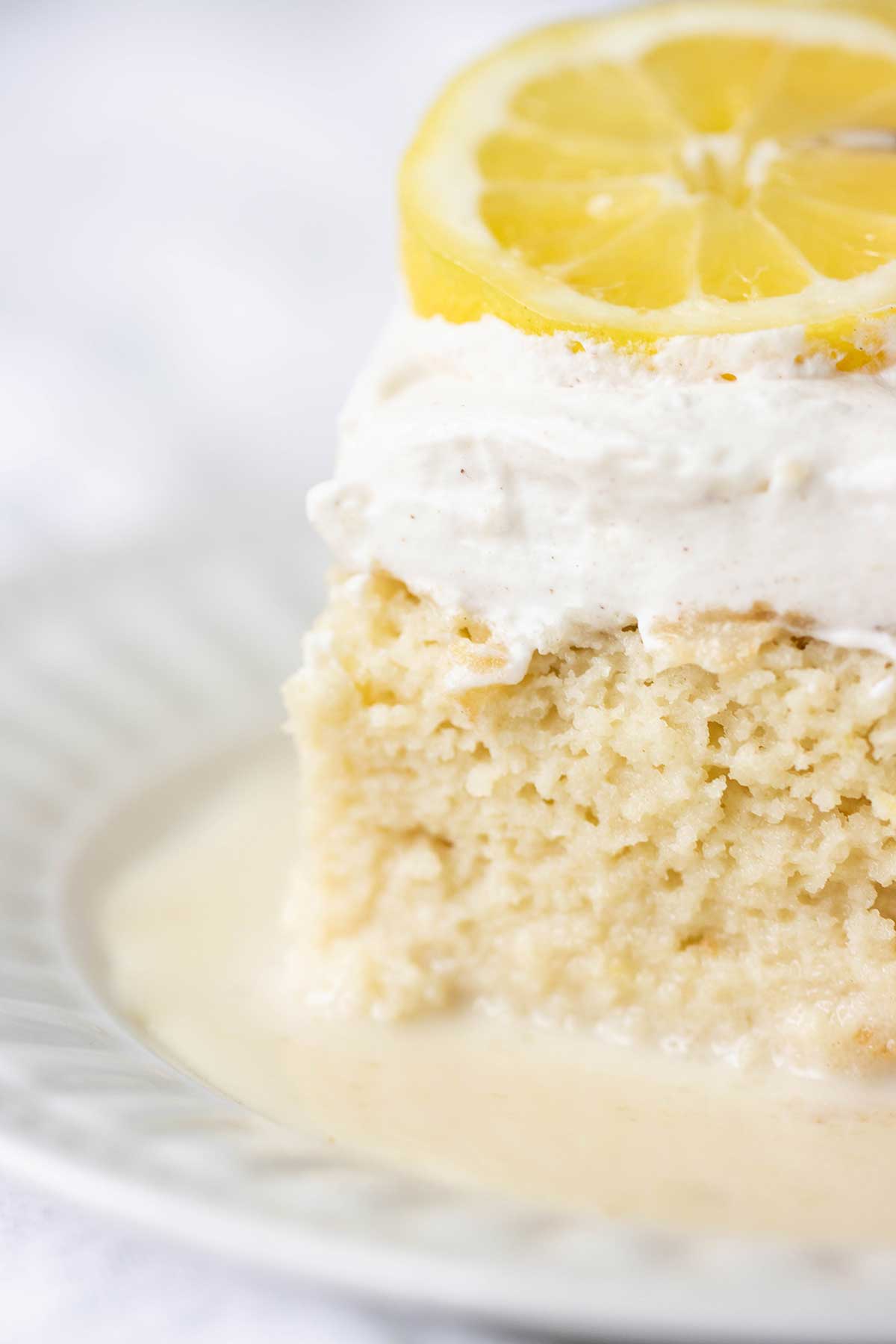 close up of a plate with a piece of a lemon tres leches cake.