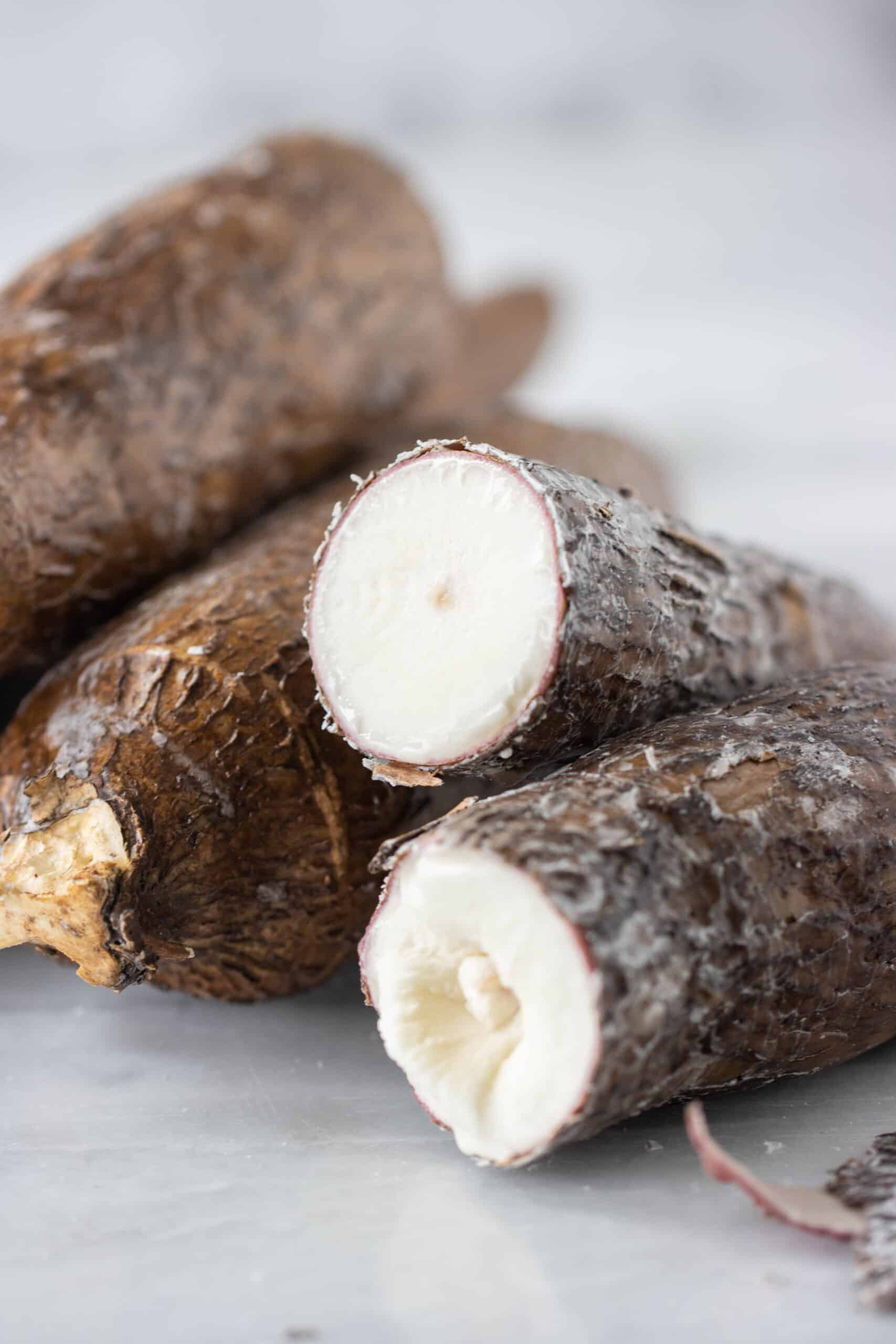 close up image of a yuca vegetable open in half with a couple of yuca on the side.