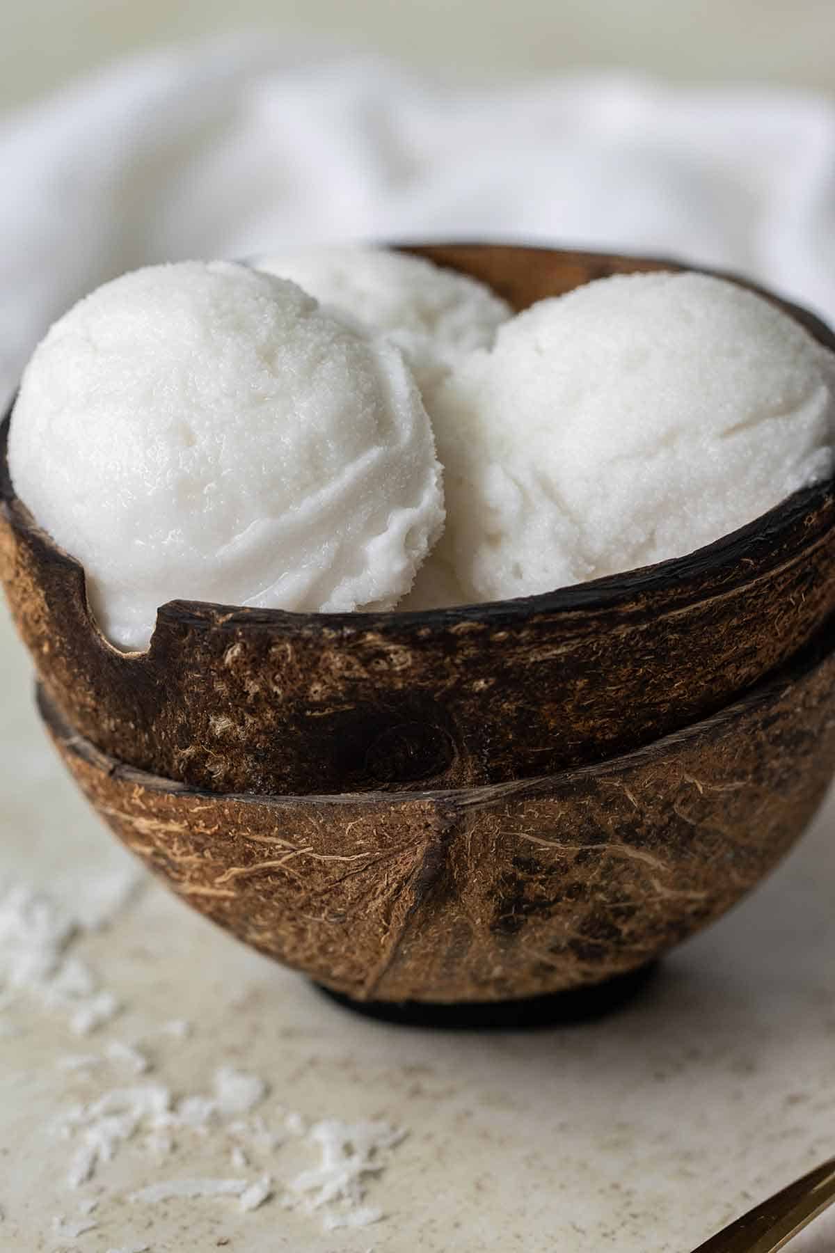 3 balls of a coconut sorbet served on a coconut shell.