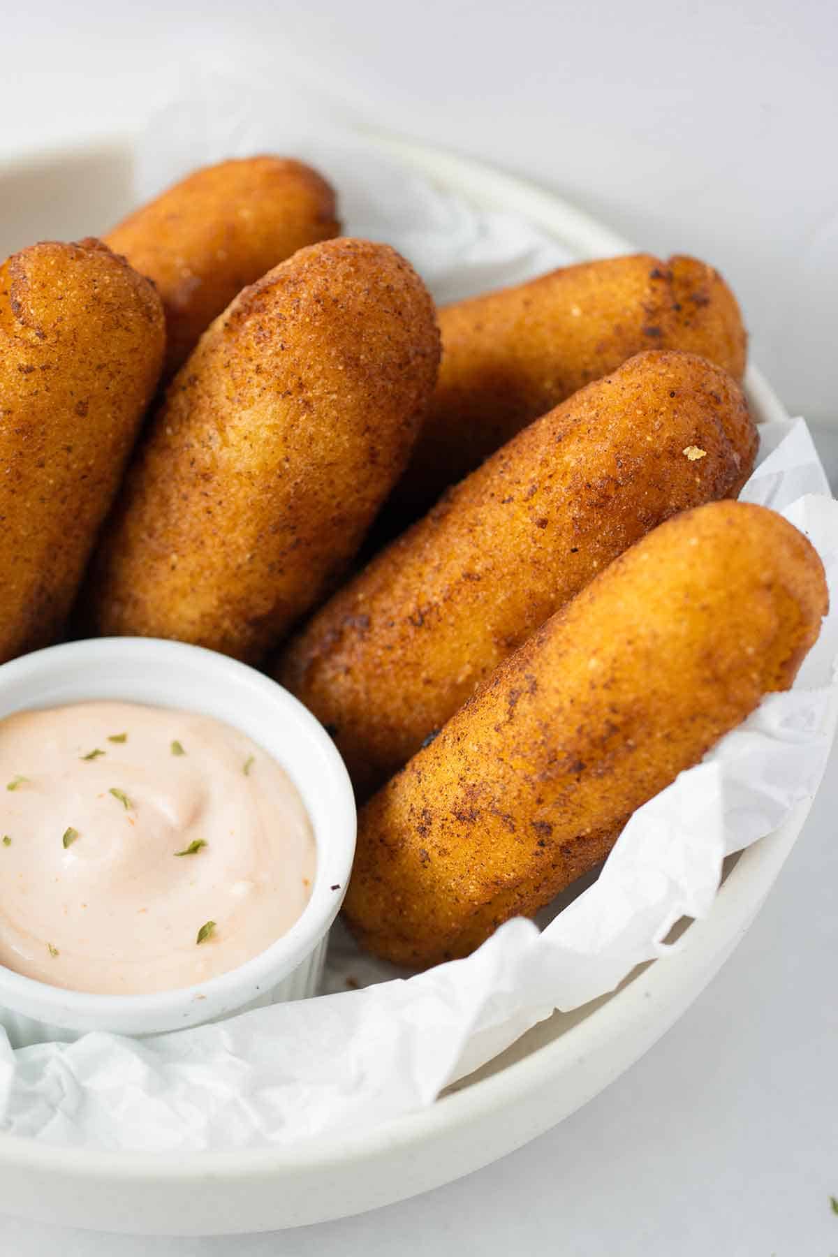 plato grande blanco con sorullitos de maiz y mayo ketchup.