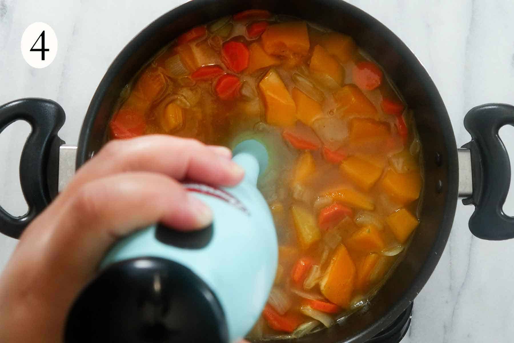 a hand blender puree chicken stock, cooked pumpkin, and carrots.