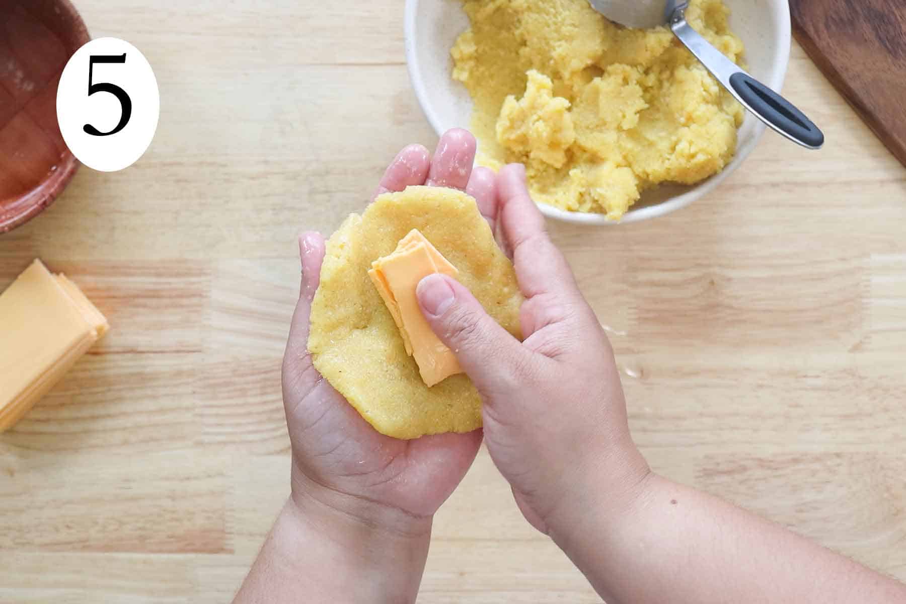 hands making sorullitos de maiz with cheese.