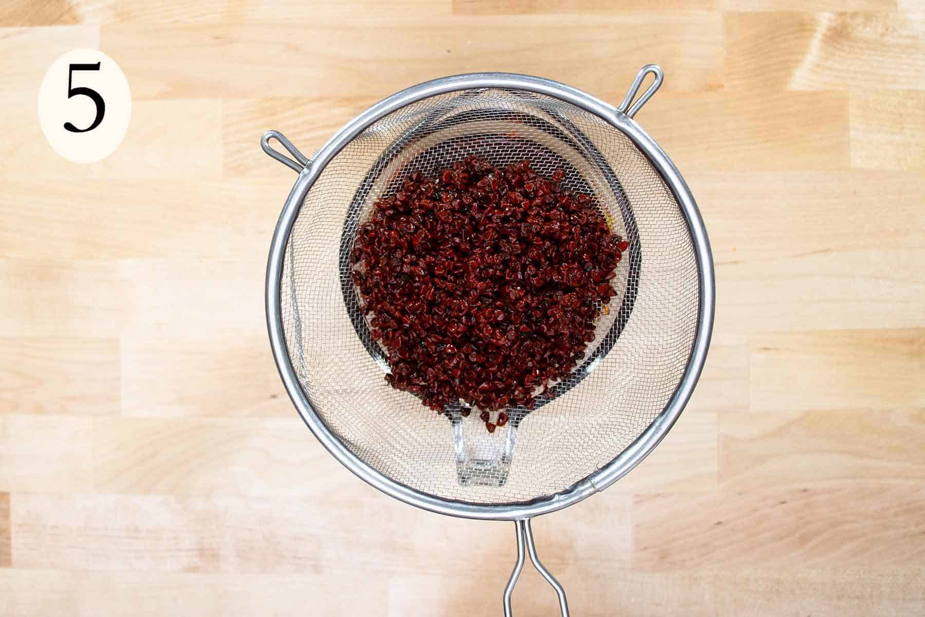 achiote seeds on a strainer.
