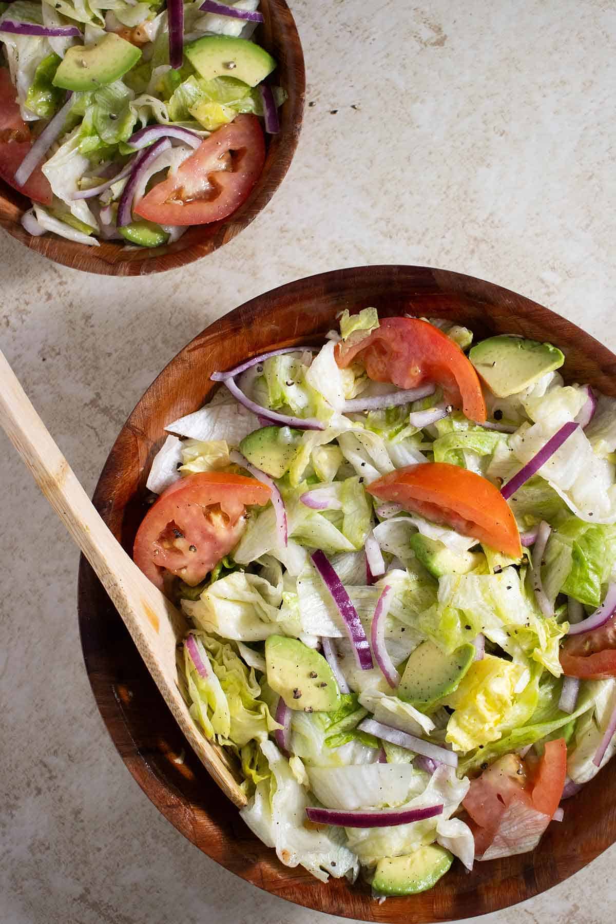 1 big bowl and a smaller one full of salad.