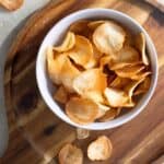 a plate full of fried yuca chips on top of a wooden ttray.