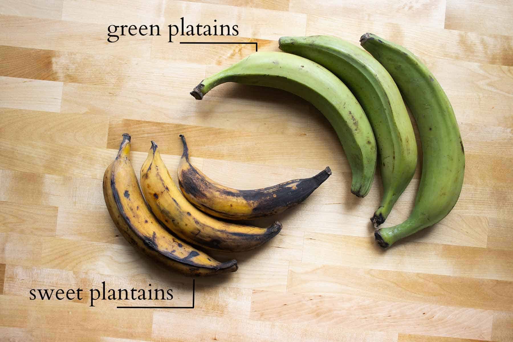 ripe and green plantains labeled on a table.