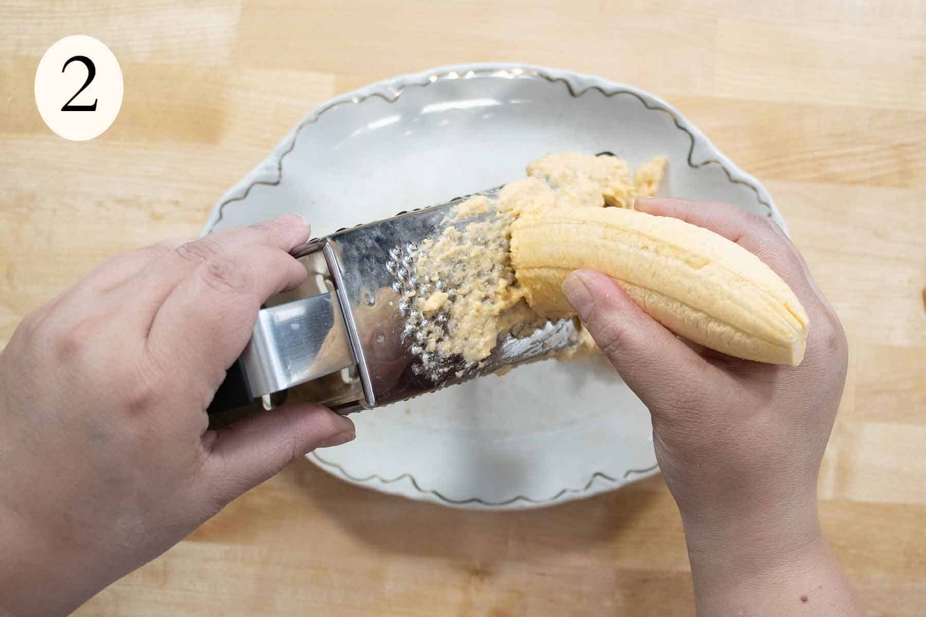 a plantain being grated into a paste.