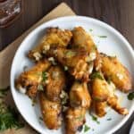 a white plate with garlic butter chicken wings.