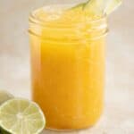 a cup with a passion fruit lemonade and a couple of limes on the side.