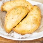 a plate with 3 pastelillos de pollo or puerto rican chicken empanadas.