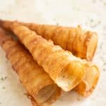 4 eggrolls cones with some parsley flakes around as garnish.