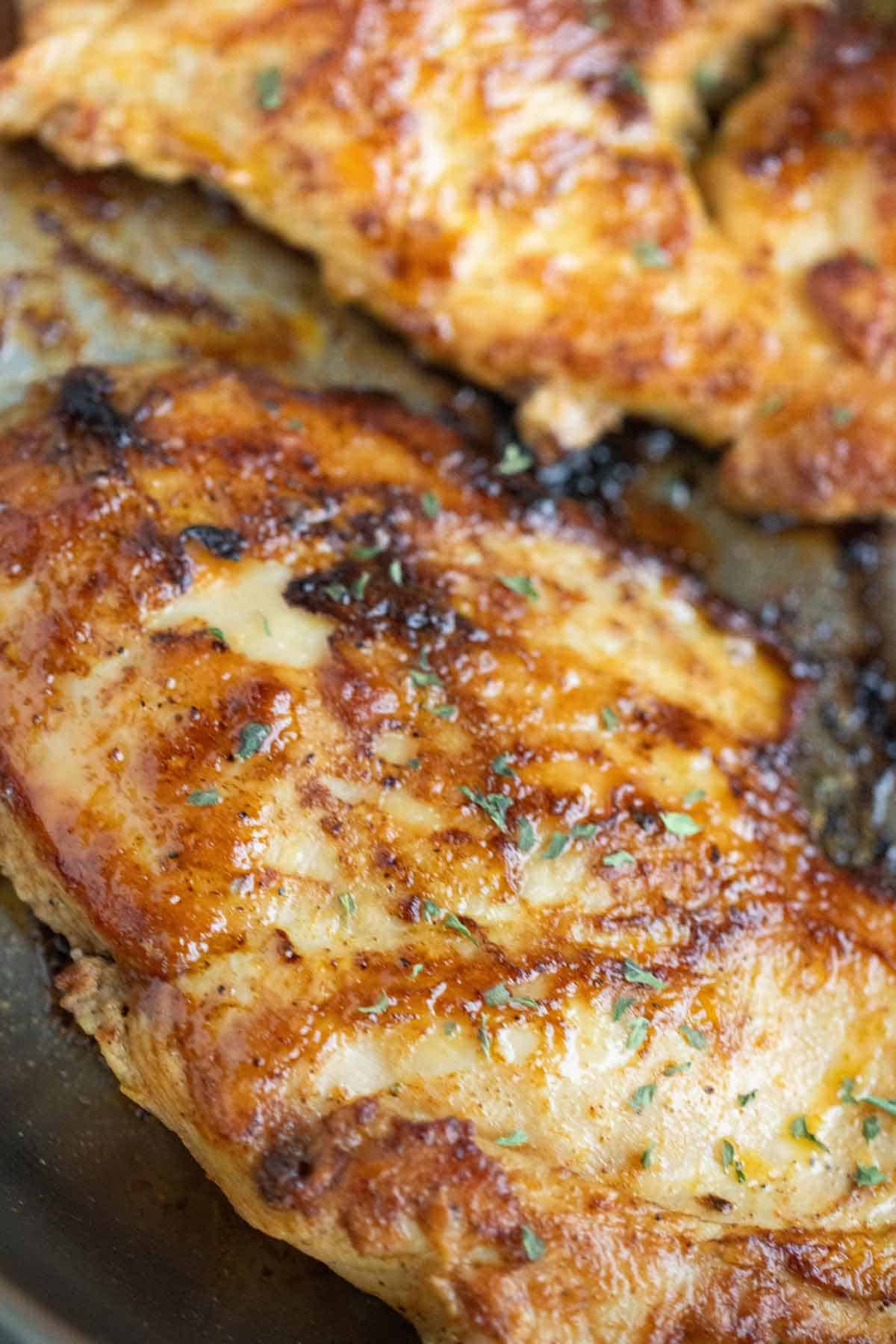 2 piezas de pechugas de pollo a la plancha con perejil de decoración.