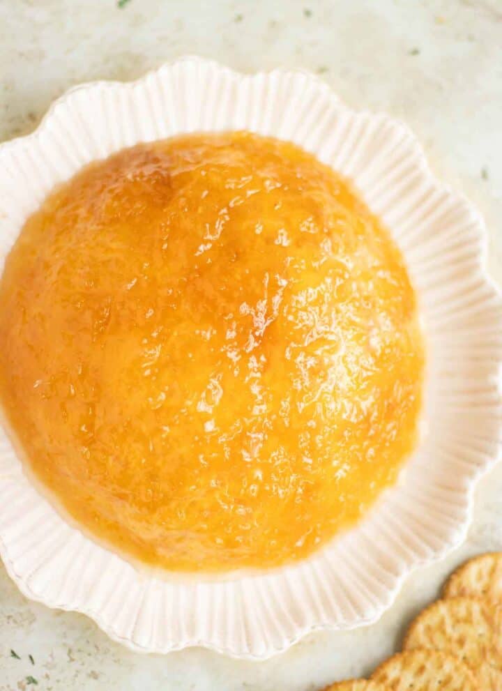 a plate with a bola de fuego dip with a few salted crackers on the side.