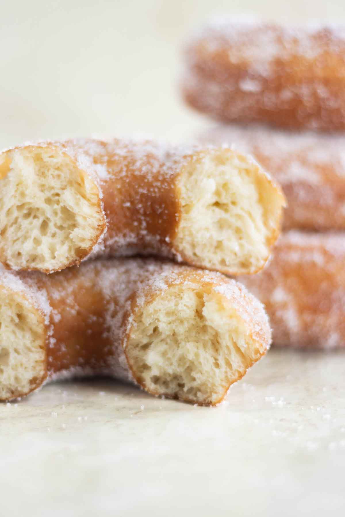 una torre de donas de azúcar con una dona al frente cortada a la mitad.