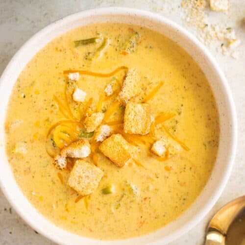 a bowl of an easy broccoli soup with cheddar cheese and croutons as topping.