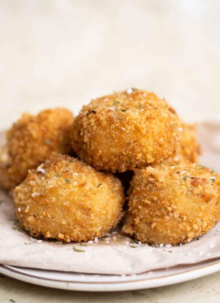 5 crispy fried balls of bacon croquettes on a plate.