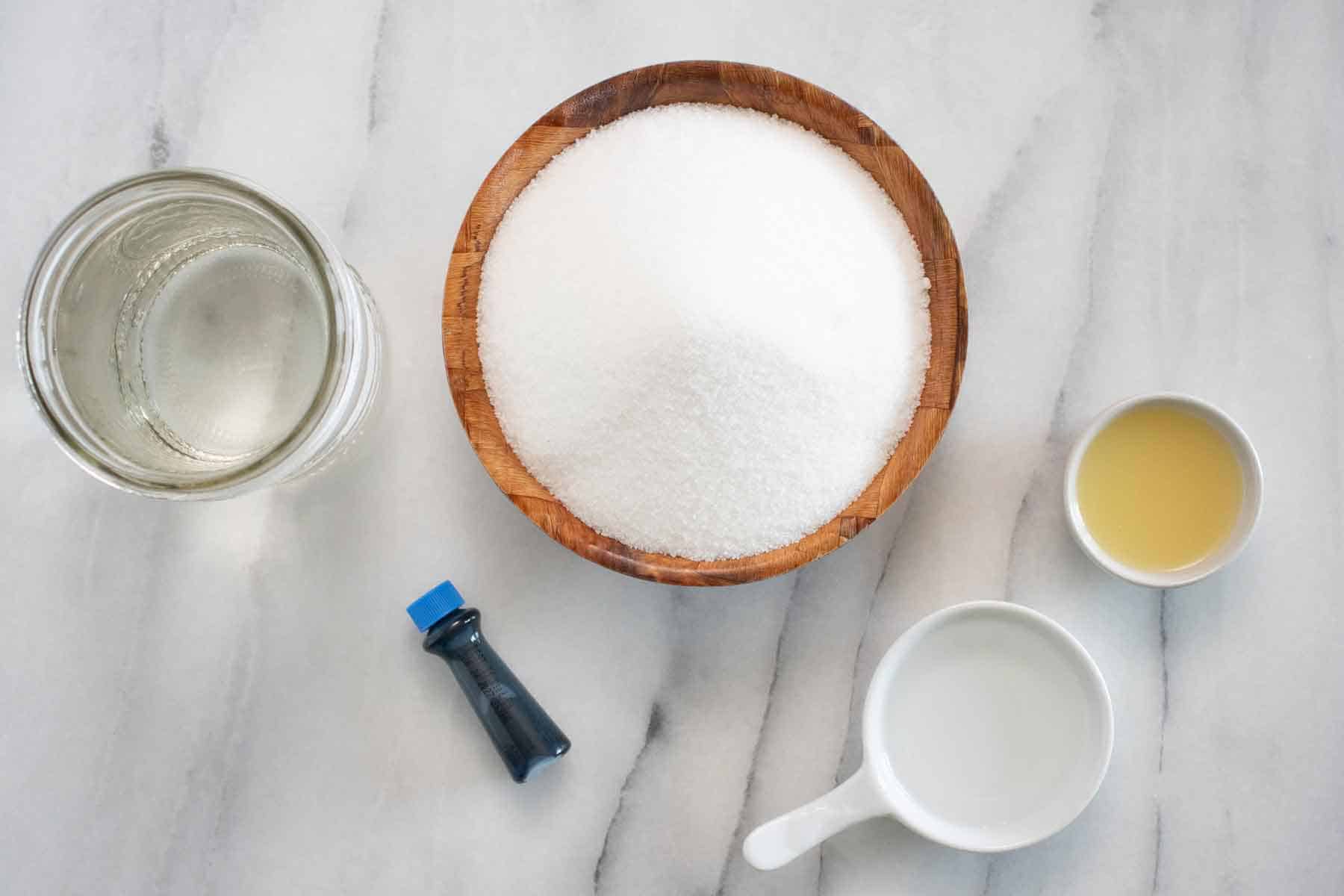 All the ingredients needed to make a Puerto Rican piragua de pitufo or blueberry flavor shaved ice piragua.