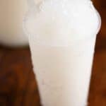 A Puerto Rican coconut piragua with a syrup bottle on the back.