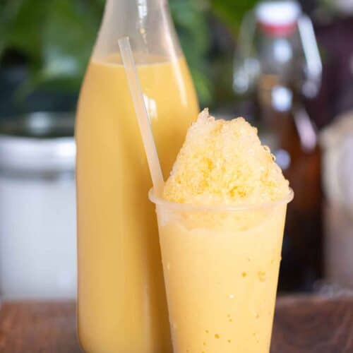 A cup of a piragua de crema or cream shaved ice with a cream syrup on the background.