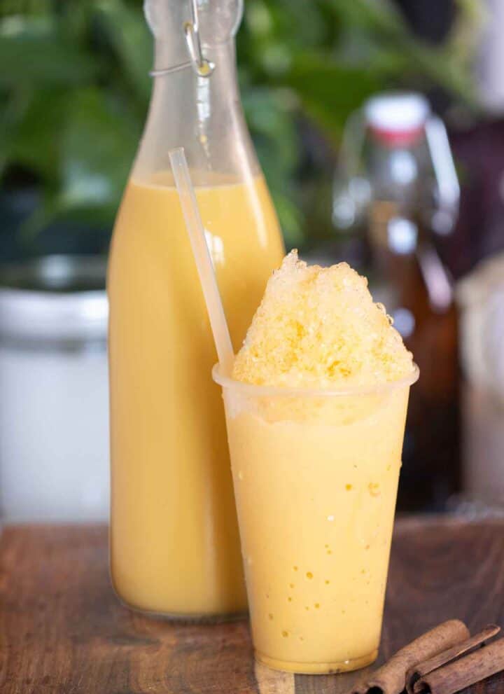A cup of a piragua de crema or cream shaved ice with a cream syrup on the background.