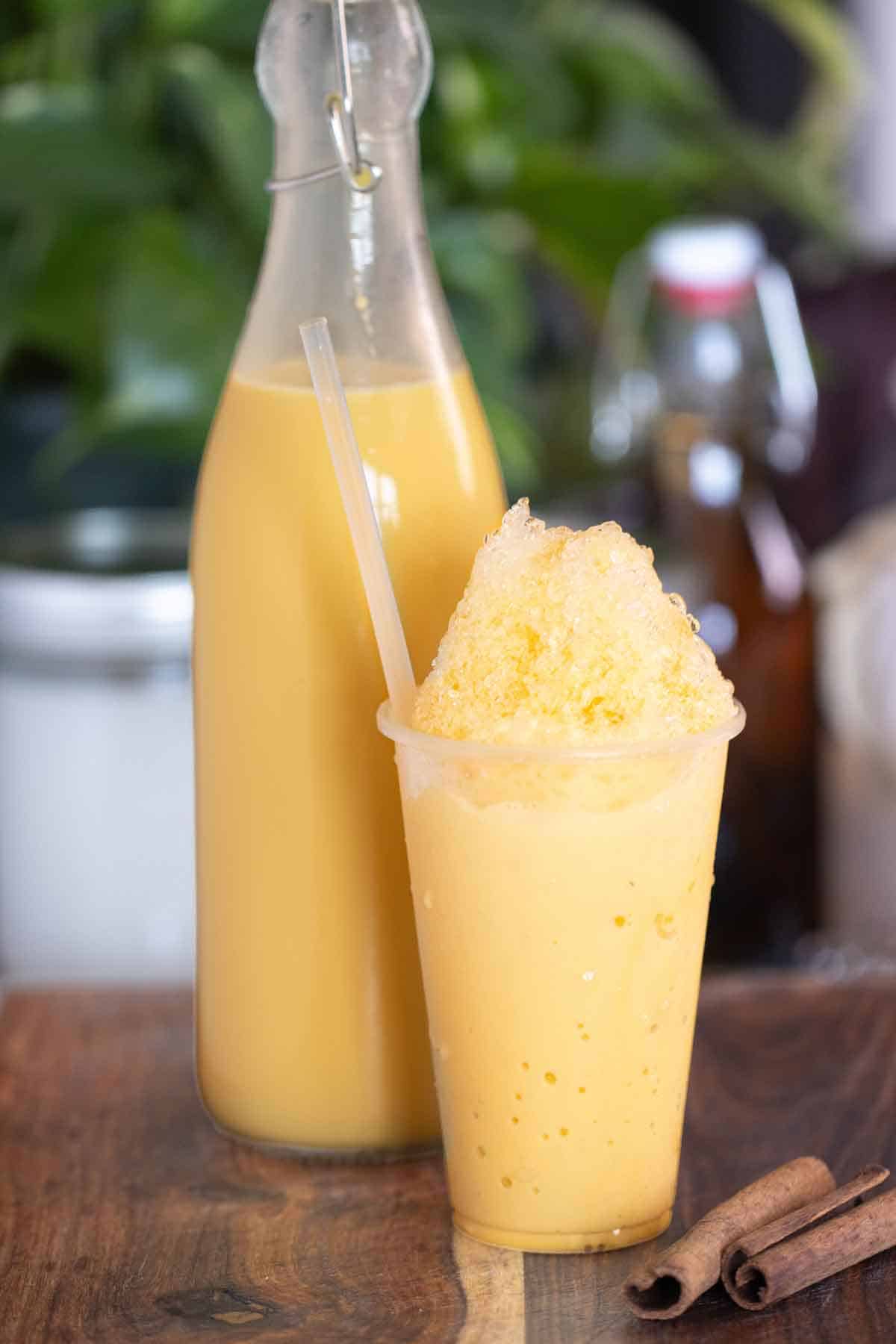 A cup of a piragua de crema or cream shaved ice with a cream syrup on the background.