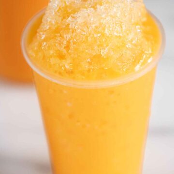 A cup of ice cream flavor shaved ice or piragua de mantecado.