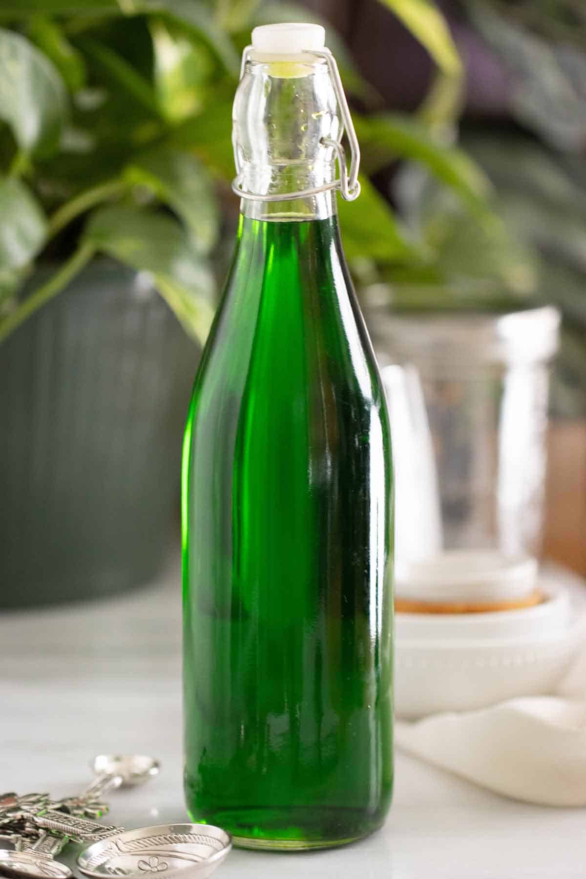 A bottle of a green homemade mint syrup used in drinks.
