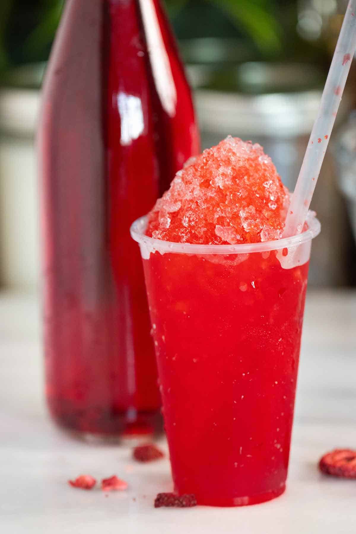 a cup with a puerto rican strawberry piragua made with the strawberry syrup on the back.