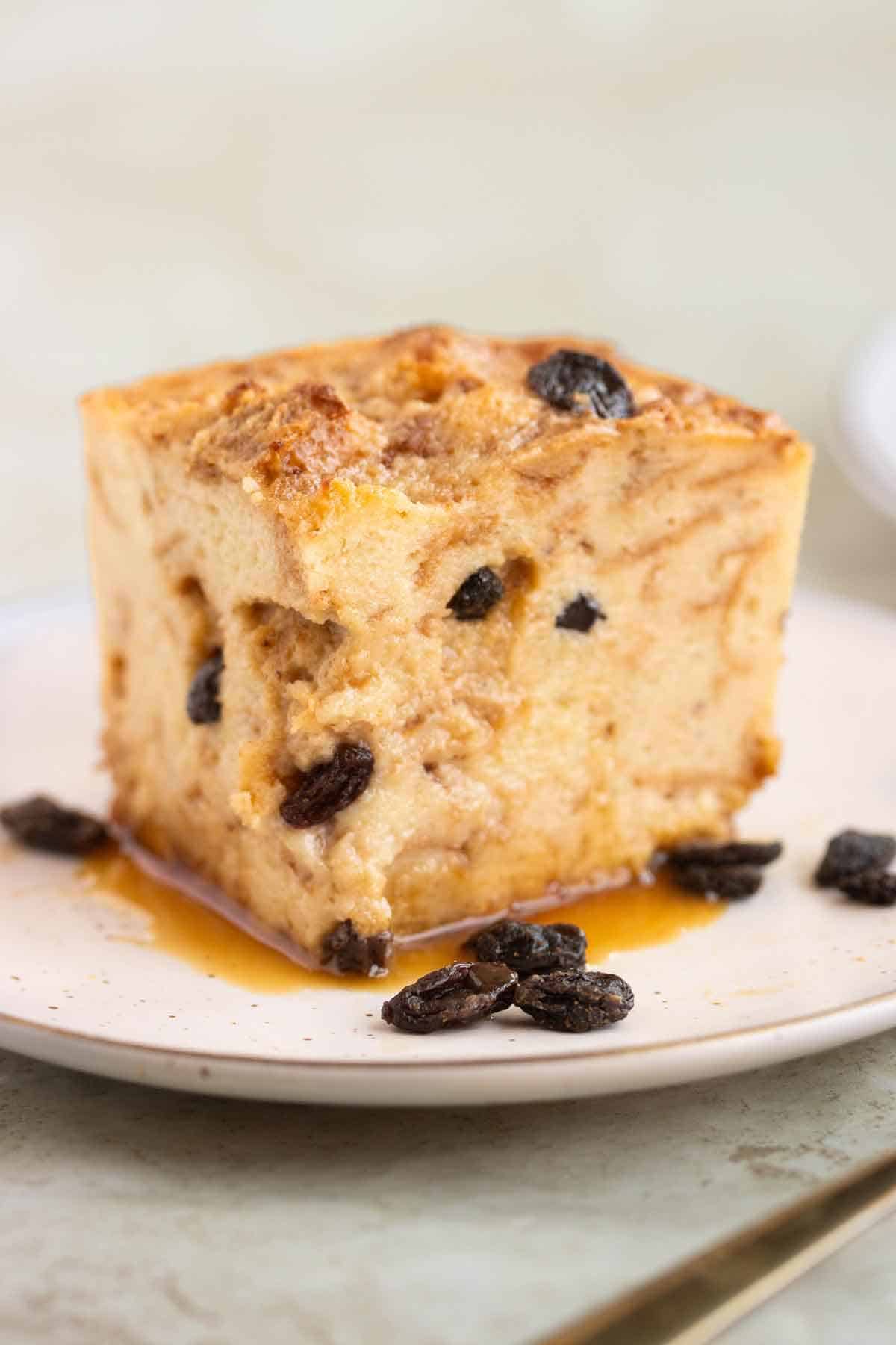 A square piece of a bread pudding with raisins and caramel.